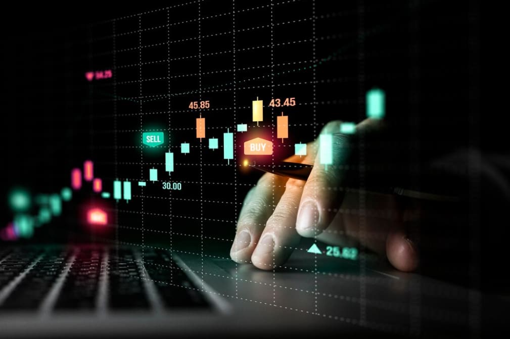 Close-up of a hand trading on a forex chart on a laptop screen with glowing buy and sell options