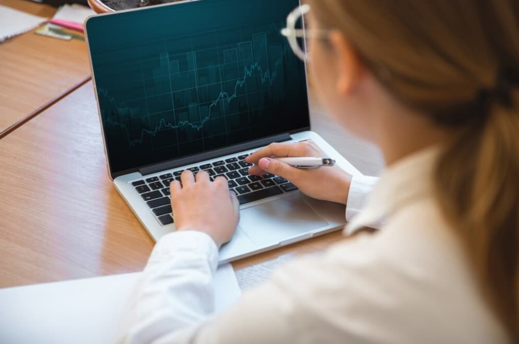 A person analyzing a financial chart on a laptop